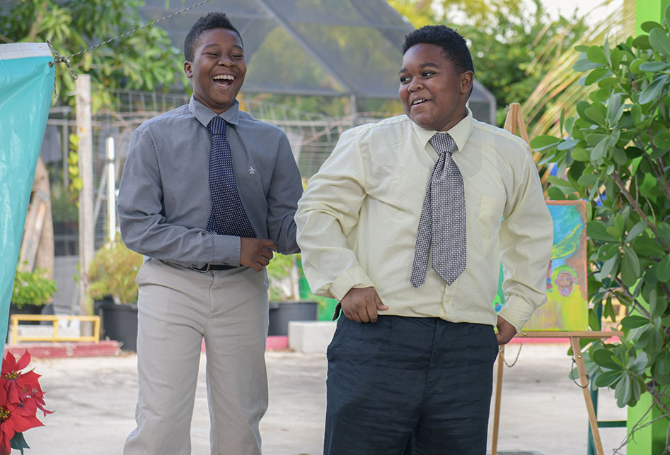 Two students laughing together in dress shirts and ties