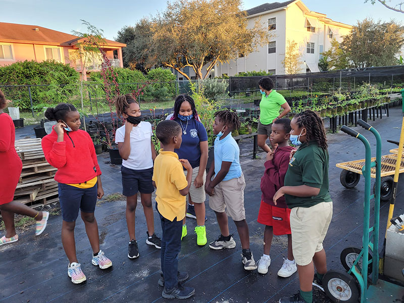 Students talking together at a community plant nursery