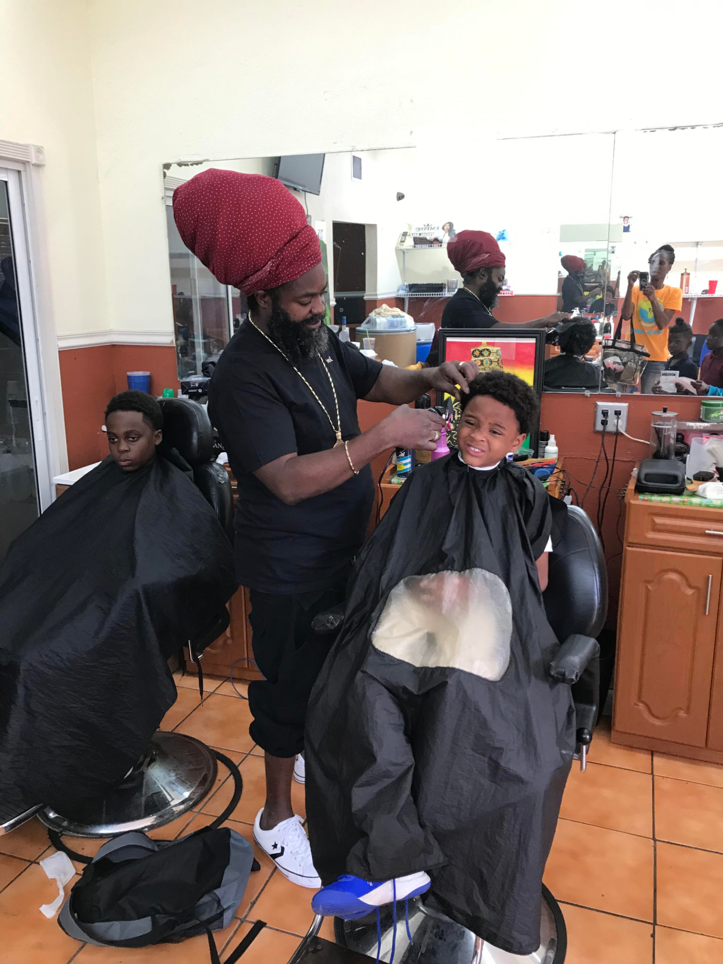 A student receiving a free haircut at a community barbershop event
