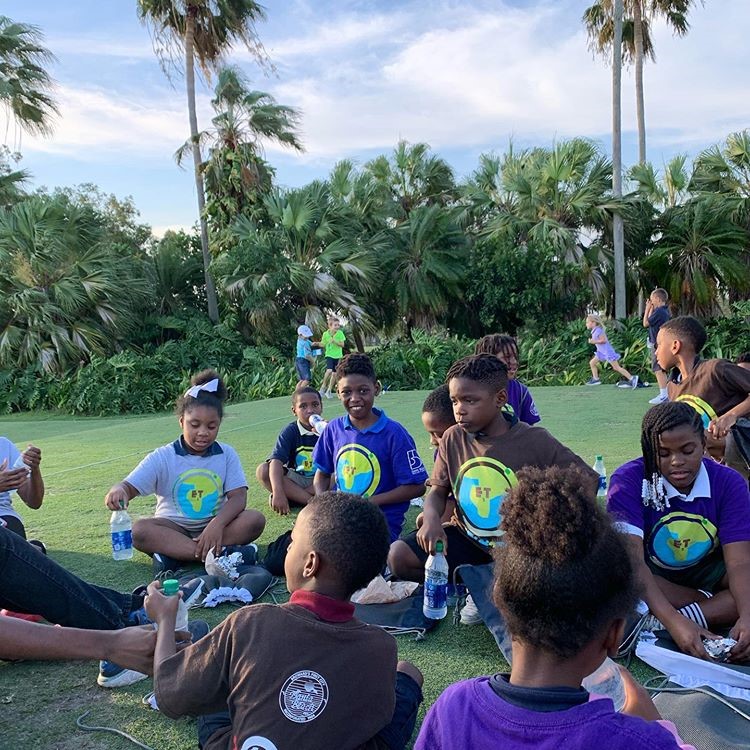 Earth 2 Table students resting on the grass at the Honda Classic