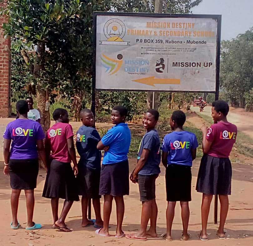 Students in Love Our Nation shirts visiting Mission Destiny School in Uganda