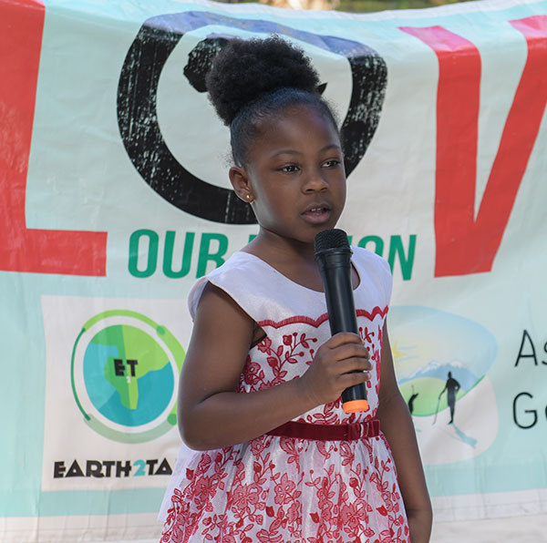 Young student speaking into a microphone at a Love Our Nation event